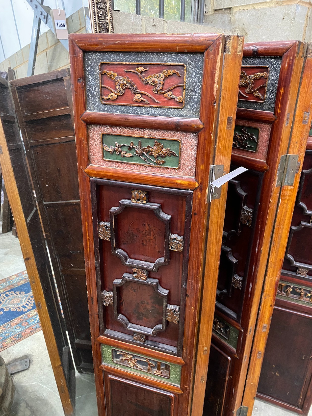 A Chinese painted carved and pierced wood seven fold screen, height 142cm